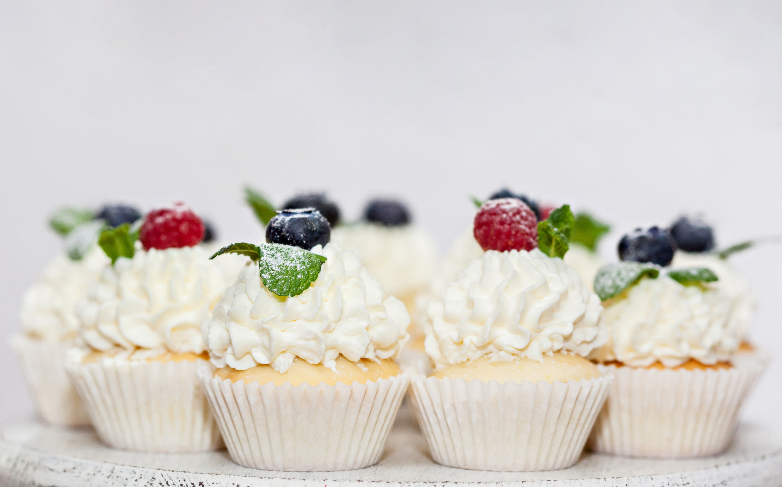 Photo of cupcakes with whipped cream on top. May 2026 Phone Sex Mistress Sascha 800-601-6875 Cupcakes